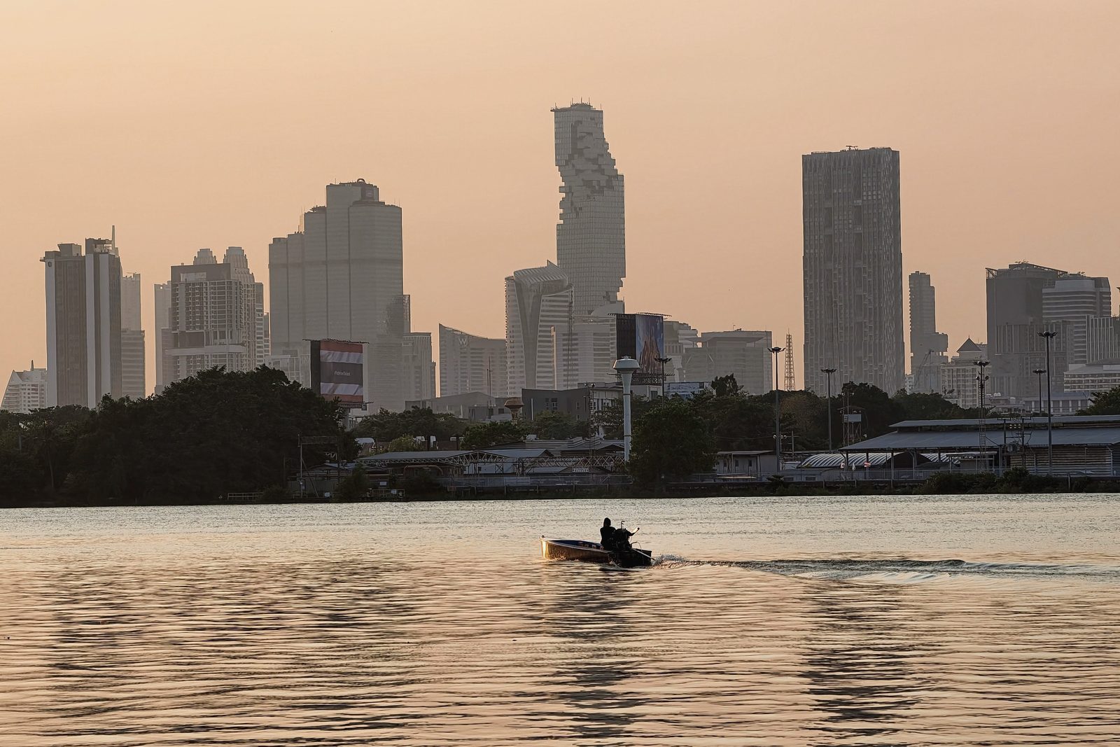 The Bangkok skyline in the evening light, with a boat on the water