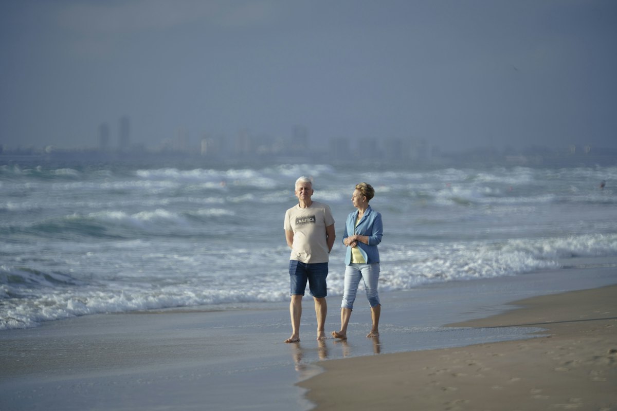 An older couple walking along a beach